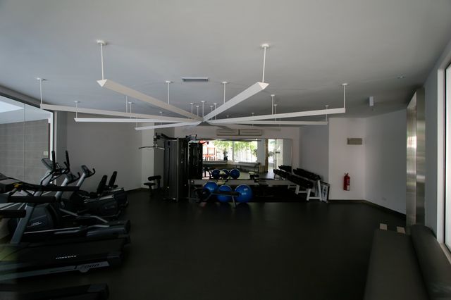 Gym with cross trainers and a large ceiling fan
